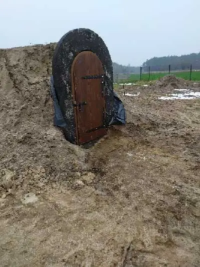 Piwniczka ogrodowa z drewnianymi drzwiami